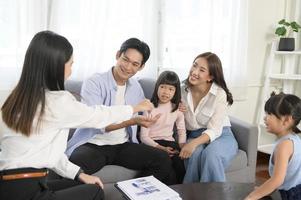 Female real estate agent explaining about the house option and offering promotions to family, Mortgage, loan, property and insurance concept. photo