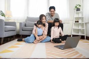 Asian family with children using laptop computer at home photo