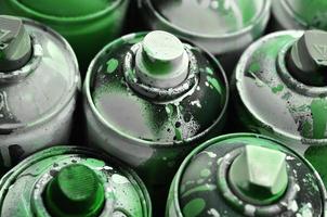 A lot of used spray cans of paint close-up. Dirty and smeared cans for drawing graffiti. The concept of a sweeping and careless drawing of paint. Creative art image photo
