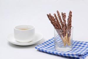 almond nut dark chocolate stick and cup of tea on white background photo