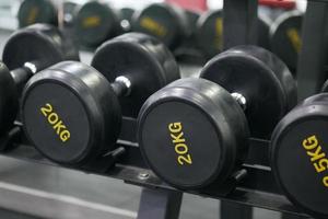 Rows of black color dumbbells with numbers in the gym photo