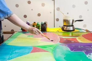 artist gets second layer of paint on silk canvas photo