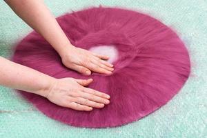 milliner presses fibers on back side of hat layout photo