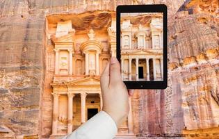 turista tomando fotos del monumento del tesoro en petra