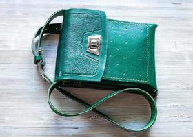 top view of green leather tablet bag on gray photo