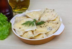 Vareniki in a bowl on wooden background photo