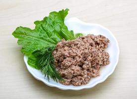 Cannded runa on the plate and wooden background photo