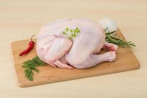 Raw chicken on wooden board and wooden background photo