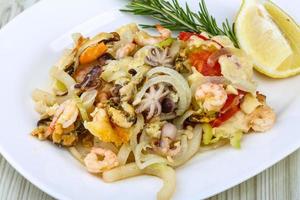 Seafood cocktail on the plate and wooden background photo