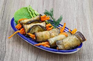 Eggplant rolls in a bowl on wooden background photo