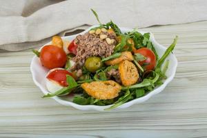 Tuna salad in a bowl on wooden background photo