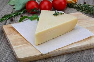 Parmesan cheese on wooden board and wooden background photo