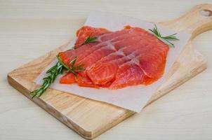 Sliced salmon on wooden board and wooden background photo