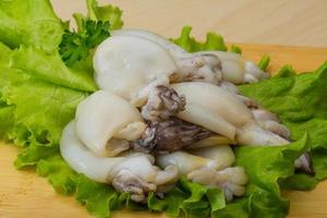 Raw cuttlefish on wooden board and wooden background photo