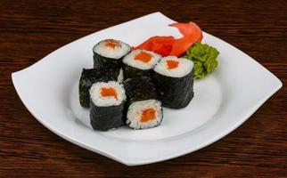 Salmon maki on the plate and wooden background photo