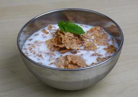 Cornflakes in a bowl on wooden background photo