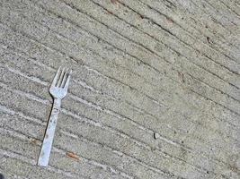 una basura de tenedor de plástico en la parte superior de una carretera de hormigón. abdominales foto