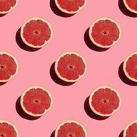 seamless pattern of fresh ripe grapefruit with a shadow on a pink background photo
