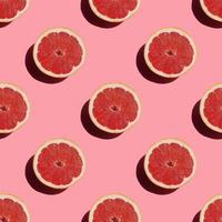 seamless pattern of fresh ripe grapefruit with a shadow on a pink background photo