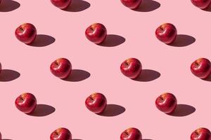 seamless pattern of a photo of a fresh ripe red apple on a pink background