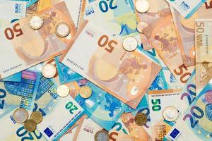 50 and 20 euro banknotes and euro coins arranged randomly photo