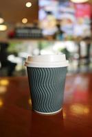 take away paper coffee cup o on cafe table photo