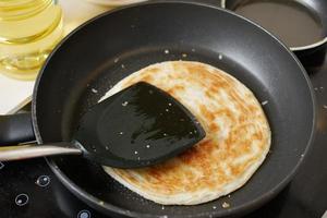 cooking roti chapati on a big cooking pan photo