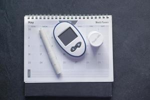 diabetic measurement tools and calendar on table photo