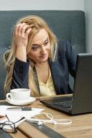 Woman looking surprised while using the laptop. photo