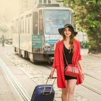 Beautiful young girl walking with blue suitcase. photo