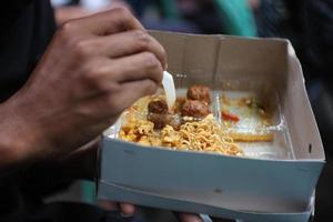 comer caja de arroz con guarniciones de fideos y arroz de maíz foto