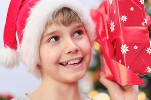 Close-up portrait of a Christmas child with a gift in his hands. photo