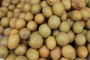 healthy and fresh sapodilla fruit neatly arranged for sale in the market. healthy and fresh fruit background photo