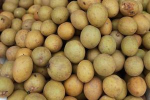 Fruto de sapodilla saludable y fresco perfectamente arreglado para la venta en el mercado. fondo de fruta sana y fresca foto