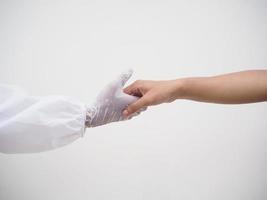 Closeup shank hand protected contact between doctor or scientist in PPE suite uniform and general people. coronavirus or COVID-19 concept isolated white background photo