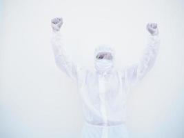 médico o científico asiático emocional exitoso en uniforme de suite ppe mientras mira hacia adelante. aprieta los puños con placer, felicidad, celebra su victoria, tiene un gran triunfo. fondo blanco aislado foto