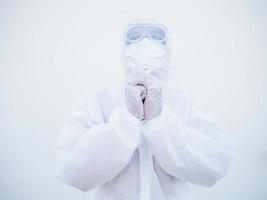 Closeup of asian male doctor or scientist in PPE suite uniform has stress and pray during an outbreak of coronavirus or COVID-19 isolated white background. photo