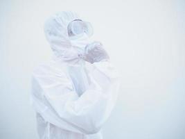 Portrait of confident asian male doctor or scientist in PPE suite uniform empty space deep thinking creative person hand on chin with looking ahead on white background. COVID-19 concept. photo