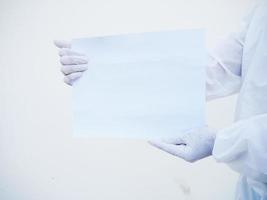 Closeup hands of doctor or scientist in PPE suite uniform holding blank paper for text with both hands While looking ahead. coronavirus or COVID-19 concept isolated white background photo