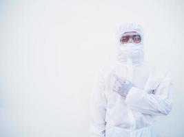 Asian male doctor or scientist in PPE suite uniform showing pointing fingers away at copy space while standing and looking forward. coronavirus or COVID-19 concept isolated white background photo