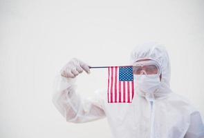 Portrait of doctor or scientist in PPE suite uniform holding national flag of United states of America. COVID-19 concept isolated white background photo