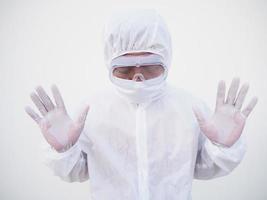 Closeup view of asian male doctor or scientist in PPE suite uniform showing stop sign while looking ahead. coronavirus or COVID-19 concept isolated white background photo