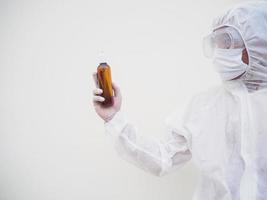 retrato de médico o científico con uniforme de suite de ppe sosteniendo una botella de plástico con un producto para el cuidado de la piel. covid-19 concepto aislado fondo blanco foto