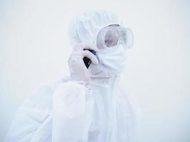 Closeup young doctor or scientist in PPE suite uniform talking on the phone with family or friend. coronavirus or COVID-19 concept isolated white background photo