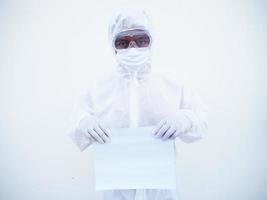 joven médico o científico con uniforme de suite ppe sosteniendo papel en blanco para texto con ambas manos mientras mira hacia adelante. concepto de coronavirus o covid-19 fondo blanco aislado foto