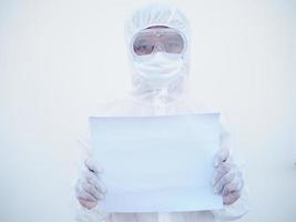 joven médico o científico con uniforme de suite ppe sosteniendo papel en blanco para texto con ambas manos mientras mira hacia adelante. concepto de coronavirus o covid-19 fondo blanco aislado foto