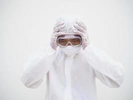 Asian male doctor or scientist in PPE suite uniform In a manner that puts his hand on his head with feeling strees and headache. coronavirus or COVID-19 concept isolated white background photo