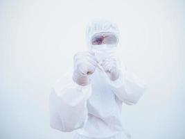 médico o científico con uniforme de suite ppe de pie con puños levantados como boxeador para pelear con coronavirus o covid-19 con fondo blanco aislado mirando hacia adelante foto