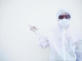 Asian male doctor or scientist in PPE suite uniform showing pointing fingers away at copy space while standing and looking forward. coronavirus or COVID-19 concept isolated white background photo