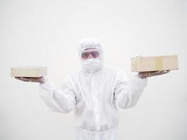 joven con uniforme de suite de ppe mientras sostiene cajas de cartón con guantes médicos de goma y máscara. concepto de coronavirus o covid-19 fondo blanco aislado foto